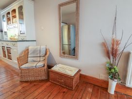 A kitchen with a wicker chair and storage box at The Studio on the Crescent in Whitby
