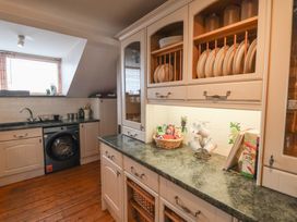 A kitchen with cabinets and a washing machine at The Studio on the Crescent in Whitby