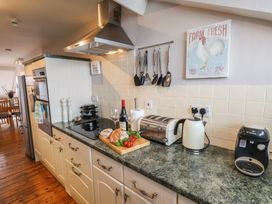 A kitchen with a stove, refrigerator and various appliances at The Studio on the Crescent in Whitby