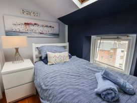 A bedroom with a bed, bedside table, and lamps at The Studio on the Crescent Whitby