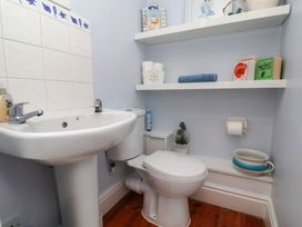 A bathroom with a sink, toilet, and shelves at The Studio on the Crescent in Whitby