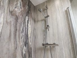 A shower with a mixer and wall tiles at The Studio on the Crescent in Whitby