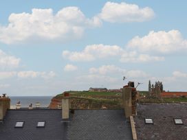 A view of rooftops overlooking the ocean and castle ruins at The Studio on the Crescent Whitby