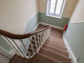 A staircase with a handrail and window at The Studio on the Crescent Whitby