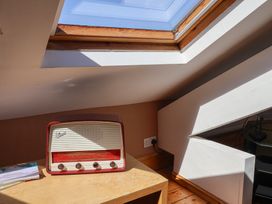 An attic with a radio on a table and a skylight at The Studio on the Crescent in Whitby