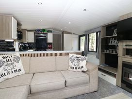 A living room with a sofa and television at Wild Duck Holiday Park in Belton, Norfolk