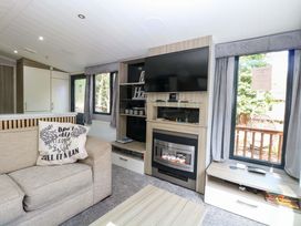 A living room with a sofa and television at Wild Duck Holiday Park in Belton, Norfolk