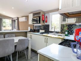 A kitchen with a table and chairs at Wild Duck Holiday Park Belton, Norfolk