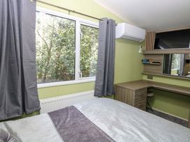 A bedroom with a bed and desk at Wild Duck Holiday Park, Belton, Norfolk
