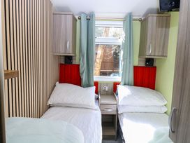 A bedroom with two beds and a window at Wild Duck Holiday Park in Belton, Norfolk