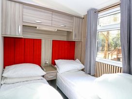 A bedroom with beds and a window at Wild Duck Holiday Park in Belton, Norfolk