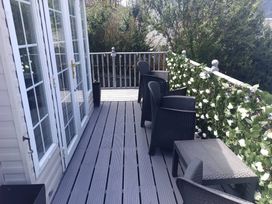 An outdoor area with chairs and tables at Clarach Bay Holiday Village - Holiday Accommodation 10536, Aberystwyth