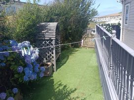 A garden with a clothesline and a wooden arch at Clarach Bay Holiday Village - Holiday Accommodation 10536 Aberystwyth
