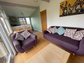 A living room with a sofa and an armchair at Hoburne Cotswolds - Holiday Accommodation 10757 Cirencester