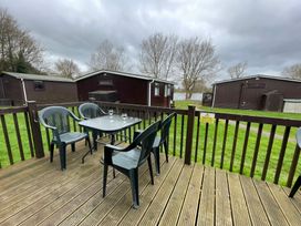 An outdoor seating area with a table and chairs at Hoburne Cotswolds - Holiday Accommodation 10757 Cirencester
