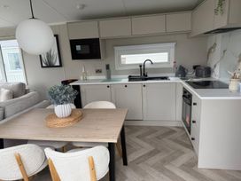 A kitchen with a table and chairs at Primrose Valley Holiday Park - Holiday Accommodation 10790, Filey