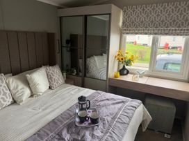 A bedroom with a bed and a window at Primrose Valley Holiday Park - Holiday Accommodation 10790, Filey