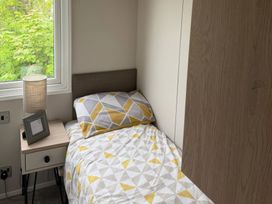 A bedroom with a bed and lamp at Primrose Valley Holiday Park - Holiday Accommodation 10790, Filey