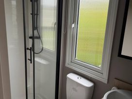 A bathroom with a shower, toilet, and sink at Primrose Valley Holiday Park - Holiday Accommodation 10790 in Filey