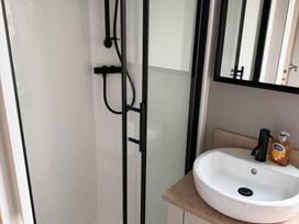 A bathroom with a shower and sink at Primrose Valley Holiday Park - Holiday Accommodation 10790, Filey