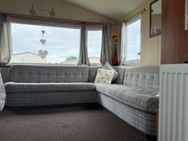 A living room with a sofa and a flower vase at Cala Gran Holiday Park - Holiday Accommodation 10830, Fleetwood