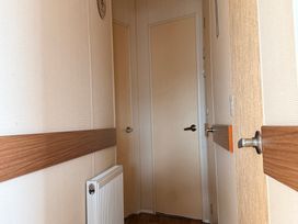 A hallway with doors and a radiator at Cala Gran Holiday Park - Holiday Accommodation 10830, Fleetwood