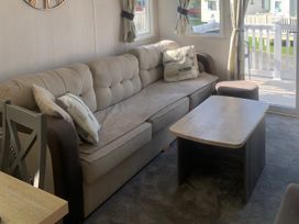 A living room with a sofa and coffee table at Kiln Park Holiday Park - Holiday Accommodation 1142 in Tenby