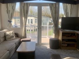A living room with a sofa and television at Kiln Park Holiday Park - Holiday Accommodation 1142, Tenby