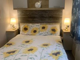 A bedroom with a bed and bedside table at Kiln Park Holiday Park - Holiday Accommodation 1142 in Tenby