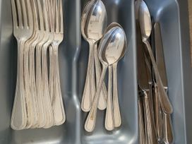 A set of cutlery including forks, spoons, and knives in a cutlery tray at Kiln Park Holiday Park - Holiday Accommodation 1142, Tenby