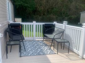 An outdoor area with chairs and a rug at Kiln Park Holiday Park - Holiday Accommodation 1142 Tenby