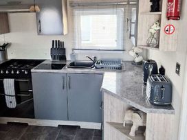 a kitchen with a stove, sink, and countertop at Silver Sands Holiday Park - Holiday Accommodation 11481 in Lossiemouth
