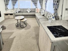 a living room with a sectional sofa and coffee tables at Silver Sands Holiday Park - Holiday Accommodation 11481, Lossiemouth