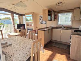 A kitchen with table and chairs at The Crest, Filey (private land) - Holiday Accommodation 11967 Filey