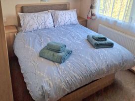 A bedroom with a double bed and towels on top at The Crest, Filey (private land) - Holiday Accommodation 11967, Filey