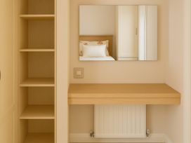 A dressing room with shelves and a mirror at Combe Haven Holiday Park - Holiday Accommodation 12122 St. Leonards-on-Sea