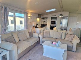 A living room with sofas and kitchen appliances at Craig Tara Holiday Park - Holiday Accommodation 12278, Ayr