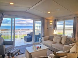 A living room with a view of the beach and ocean at Craig Tara Holiday Park - Holiday Accommodation 12278 Ayr