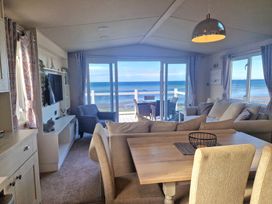 A living room with a sliding door and dining table at Craig Tara Holiday Park - Holiday Accommodation 12278 in Ayr