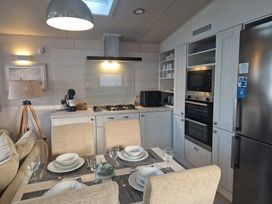 A kitchen with appliances and dining table at Craig Tara Holiday Park - Holiday Accommodation 12278 Ayr