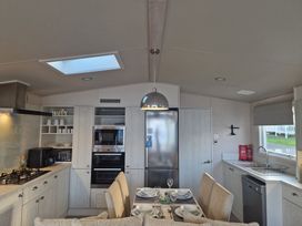 A kitchen with appliances and dining setup at Craig Tara Holiday Park - Holiday Accommodation 12278, Ayr