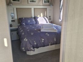 A bedroom with a bed and bedside table at Craig Tara Holiday Park - Holiday Accommodation 12278 Ayr