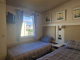 A bedroom with two beds and a television at Craig Tara Holiday Park - Holiday Accommodation 12278, Ayr