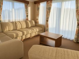A living room with a sofa and coffee table at Freshwater Beach Holiday Park - Holiday Accommodation 12281 in Burton Bradstock