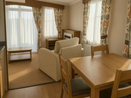 A living room with a sofa and table at Freshwater Beach Holiday Park - Holiday Accommodation 12281, Burton Bradstock