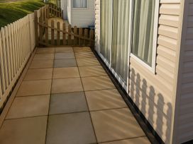 A patio with a sliding door and fence at Freshwater Beach Holiday Park - Holiday Accommodation 12281, Burton Bradstock