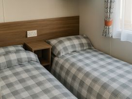 two single beds with plaid bedding in a room at Freshwater Beach Holiday Park - Holiday Accommodation 12281 in Burton Bradstock