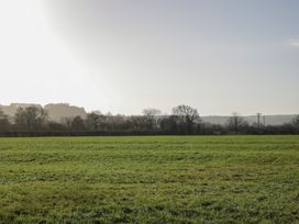 A field with trees in the background at Maud Heath's Snug East Thytherton