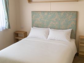 A bedroom with a bed and bedside tables at Lyons Sunnysands Holiday Park - Holiday Accommodation 12581, Barmouth