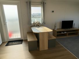 A dining area with a table and benches at Littlesea Holiday Park - Holiday Accommodation 13127 Weymouth